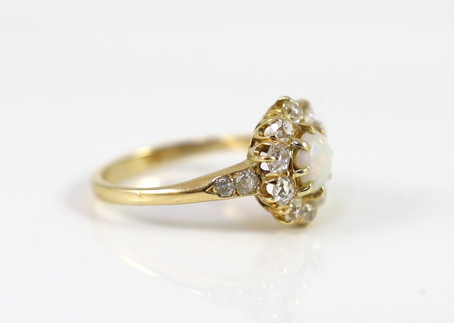 An early 20th century gold, white opal and diamond set circular cluster ring